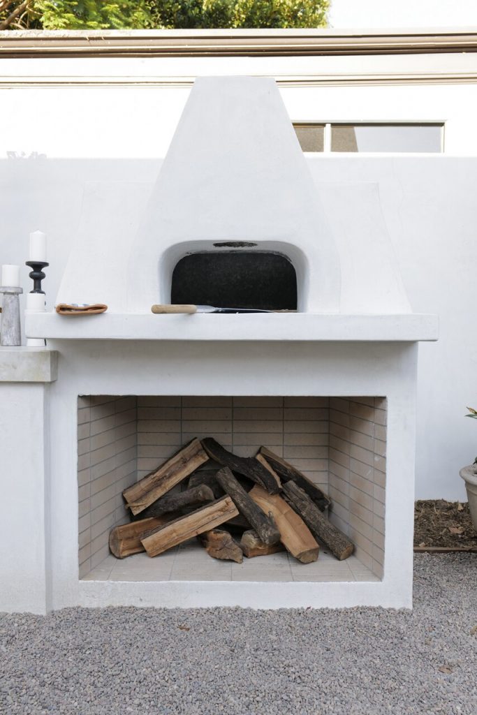 White outdoor fireplace with wood