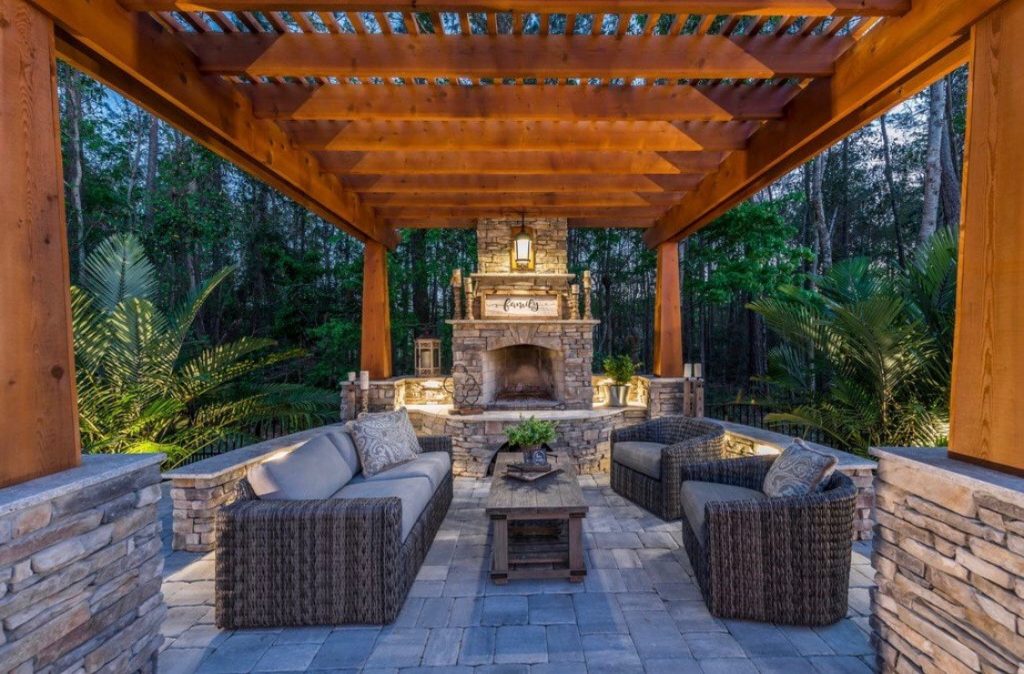 Outdoor fireplace with pergola and sofa area
