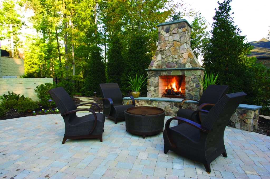 Outdoor space with fireplace and sofa area